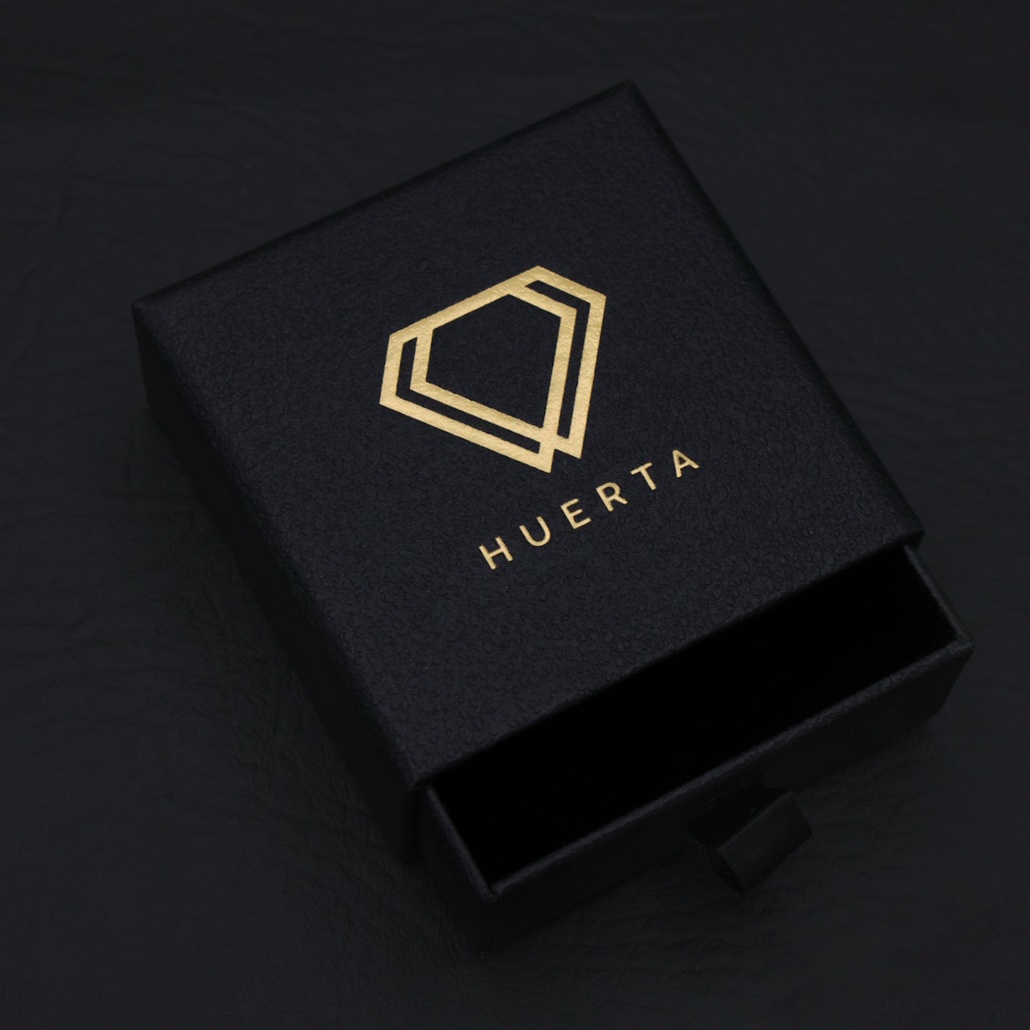 White jewelry box with 'HUERTA' branding on a black background